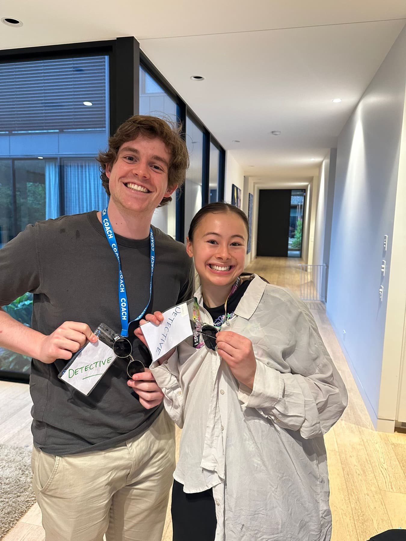 Two guests smiling and holding detective role cards at an Inspector Byte event